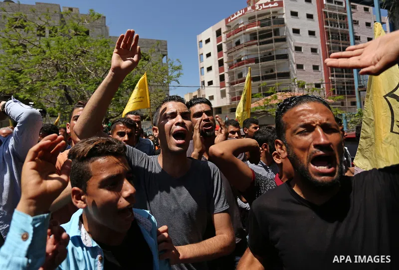 Palestinian mourners carry the body of Mohammed Majed Bakr, a 25-year-old fisherman who died from his injuries after an Israeli patrol vessel fired at a fishing boat, during his funeral in Gaza City on May 16, 2017. The...