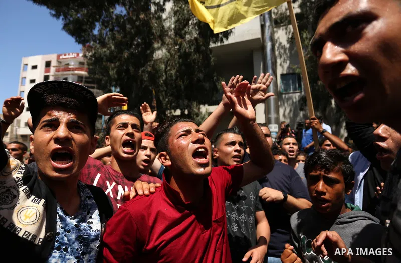 Palestinian mourners carry the body of Mohammed Majed Bakr, a 25-year-old fisherman who died from his injuries after an Israeli patrol vessel fired at a fishing boat, during his funeral in Gaza City on May 16, 2017. The...