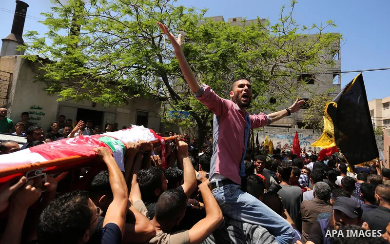 Palestinian mourners carry the body of Mohammed Majed Bakr, a 25-year-old fisherman who died from his injuries after an Israeli patrol vessel fired at a fishing boat, during his funeral in Gaza City on May 16, 2017. The...