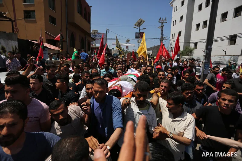 Palestinian mourners carry the body of Mohammed Majed Bakr, a 25-year-old fisherman who died from his injuries after an Israeli patrol vessel fired at a fishing boat, during his funeral in Gaza City on May 16, 2017. The...
