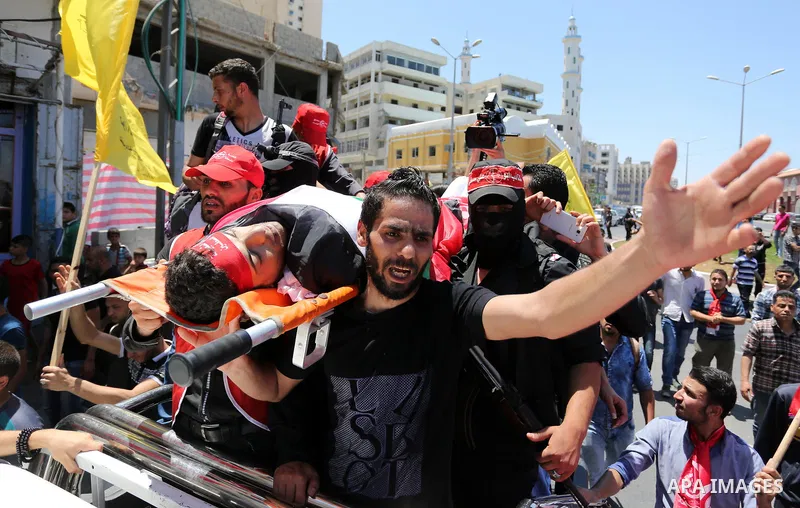 Palestinian mourners carry the body of Mohammed Majed Bakr, a 25-year-old fisherman who died from his injuries after an Israeli patrol vessel fired at a fishing boat, during his funeral in Gaza City on May 16, 2017. The...
