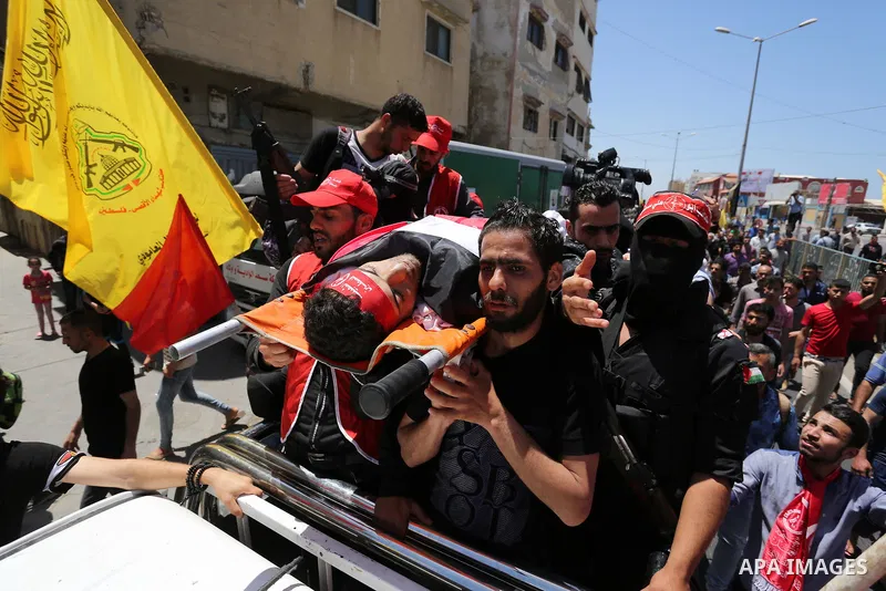 Palestinian mourners carry the body of Mohammed Majed Bakr, a 25-year-old fisherman who died from his injuries after an Israeli patrol vessel fired at a fishing boat, during his funeral in Gaza City on May 16, 2017. The...