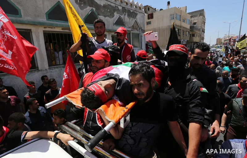 Palestinian mourners carry the body of Mohammed Majed Bakr, a 25-year-old fisherman who died from his injuries after an Israeli patrol vessel fired at a fishing boat, during his funeral in Gaza City on May 16, 2017. The...