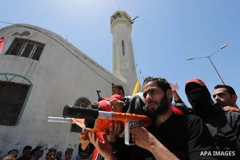 Palestinian mourners carry the body of Mohammed Majed Bakr, a 25-year-old fisherman who died from his injuries after an Israeli patrol vessel fired at a fishing boat, during his funeral in Gaza City on May 16, 2017. The...