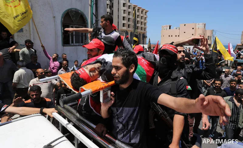 Palestinian mourners carry the body of Mohammed Majed Bakr, a 25-year-old fisherman who died from his injuries after an Israeli patrol vessel fired at a fishing boat, during his funeral in Gaza City on May 16, 2017. The...