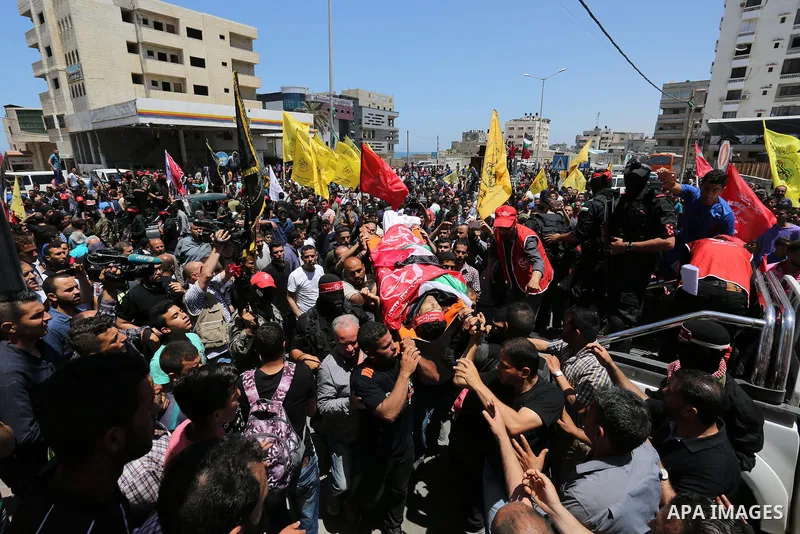 Palestinian mourners carry the body of Mohammed Majed Bakr, a 25-year-old fisherman who died from his injuries after an Israeli patrol vessel fired at a fishing boat, during his funeral in Gaza City on May 16, 2017. The...