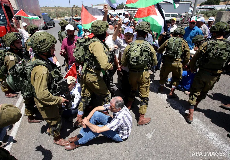 Israeli soldiers scuffle with Palestinian protesters trying to block the main road between the West Bank city of Nablus and the Jewish settlement of Shavi Shamron during a demonstration in solidarity with Palestinian pri...