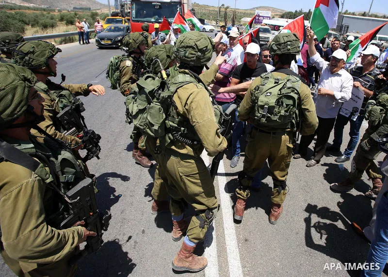 Israeli soldiers scuffle with Palestinian protesters trying to block the main road between the West Bank city of Nablus and the Jewish settlement of Shavi Shamron during a demonstration in solidarity with Palestinian pri...