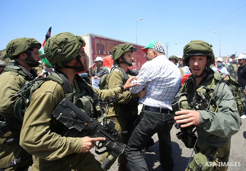 Israeli soldiers scuffle with Palestinian protesters trying to block the main road between the West Bank city of Nablus and the Jewish settlement of Shavi Shamron during a demonstration in solidarity with Palestinian pri...