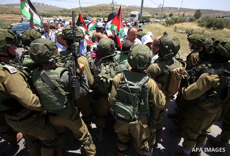 Israeli soldiers scuffle with Palestinian protesters trying to block the main road between the West Bank city of Nablus and the Jewish settlement of Shavi Shamron during a demonstration in solidarity with Palestinian pri...