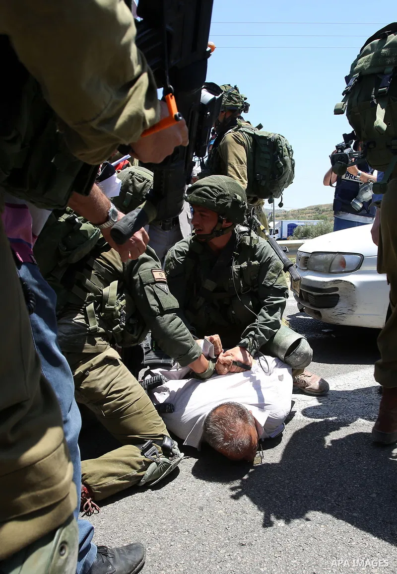 Israeli soldiers detain a Palestinian protester trying to block the main road between the West Bank city of Nablus and the Jewish settlement of Shavi Shamron during a demonstration in solidarity with Palestinian prisoner...