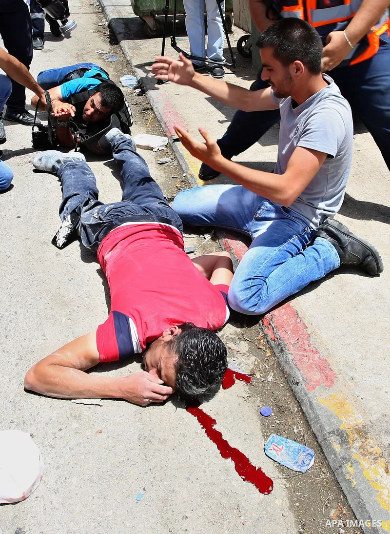 Palestinians carry a wounded photojournalist after he was allegedly killed by Israeli settler during clashes at Huwwara village, near the West Bank, 18 May 2017. According to media sources, a Palestinian was allegedly sh...