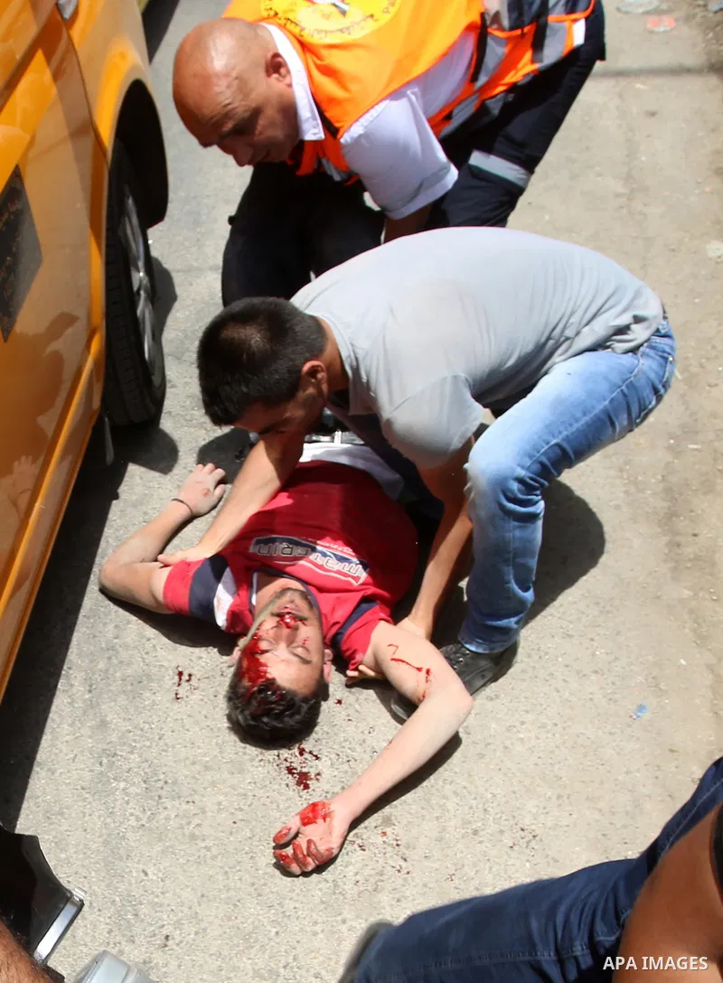 Palestinians carry a wounded photojournalist after he was allegedly killed by Israeli settler during clashes at Huwwara village, near the West Bank, 18 May 2017. According to media sources, a Palestinian was allegedly sh...