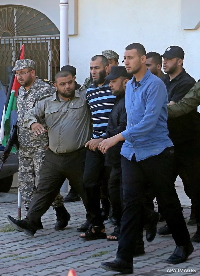 Palestinian security forces escort Ashraf Abu Leila, a 38-year-old Palestinian man convicted of the murder of Hamas military commander Mazen Faqha, out of the military court in Gaza City, on May 21, 2017. A court in the...