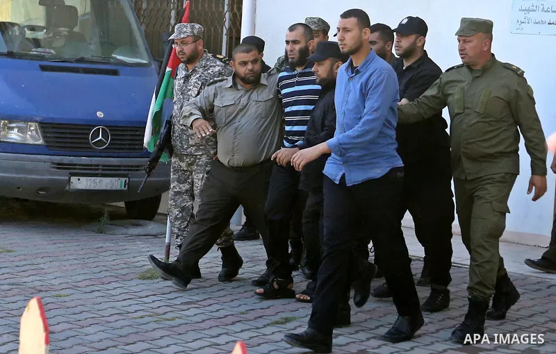 Palestinian security forces escort Ashraf Abu Leila, a 38-year-old Palestinian man convicted of the murder of Hamas military commander Mazen Faqha, out of the military court in Gaza City, on May 21, 2017. A court in the...