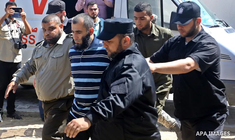 Palestinian security forces escort Ashraf Abu Leila, a 38-year-old Palestinian man convicted of the murder of Hamas military commander Mazen Faqha, out of the military court in Gaza City, on May 21, 2017. A court in the...
