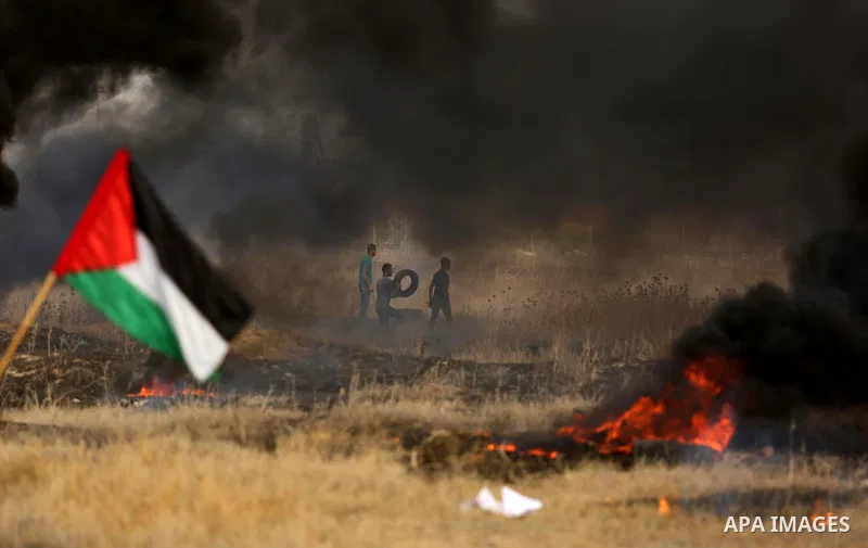 Palestinian protesters burn tires during clashes with Israeli security forces following a protest against the blockade on Gaza Strip, near the border fence east of Gaza City on May 22, 2017. Photo by Ashraf Amra