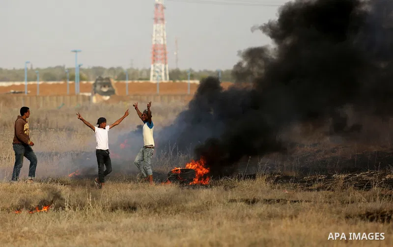Palestinian protesters burn tires during clashes with Israeli security forces following a protest against the blockade on Gaza Strip, near the border fence east of Gaza City on May 22, 2017. Photo by Ashraf Amra