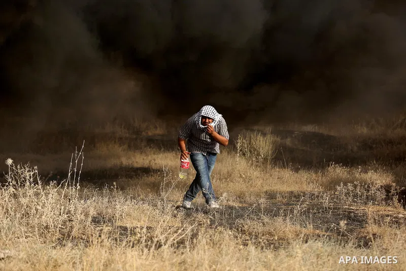 A Palestinian protester burns tires during clashes with Israeli security forces following a protest against the blockade on Gaza Strip, near the border fence east of Gaza City on May 22, 2017. Photo by Ashraf Amra