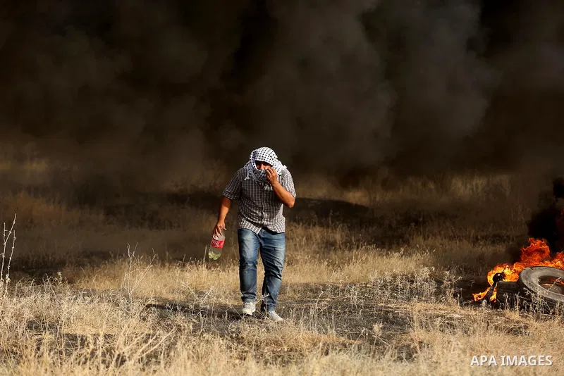 A Palestinian protester burns tires during clashes with Israeli security forces following a protest against the blockade on Gaza Strip, near the border fence east of Gaza City on May 22, 2017. Photo by Ashraf Amra