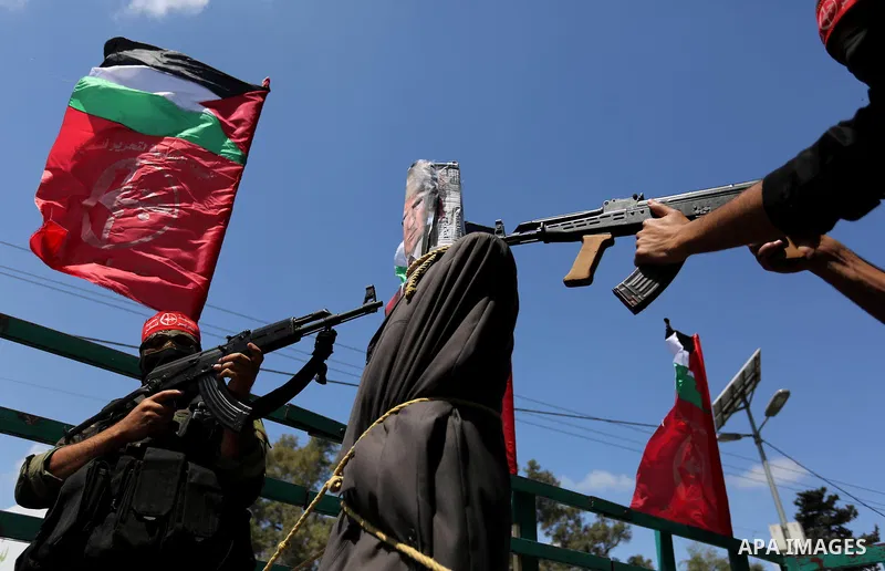 Palestinian militants from the Popular Front for the Liberation of Palestine (PFLP) aim their weapons at an effigy depicting U.S. President Donald Trump, in Gaza City May 23, 2017. Photo by Ashraf Amra