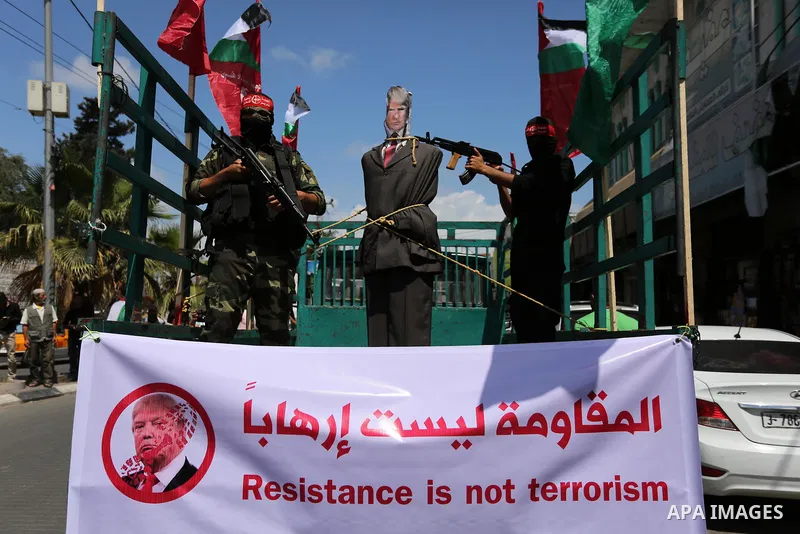 Palestinian militants from the Popular Front for the Liberation of Palestine (PFLP) aim their weapons at an effigy depicting U.S. President Donald Trump, in Gaza City May 23, 2017. Photo by Ashraf Amra