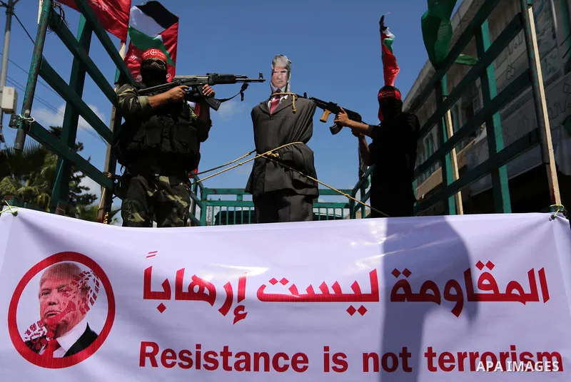 Palestinian militants from the Popular Front for the Liberation of Palestine (PFLP) aim their weapons at an effigy depicting U.S. President Donald Trump, in Gaza City May 23, 2017. Photo by Ashraf Amra