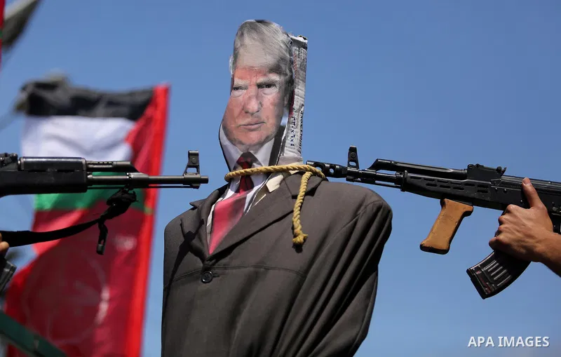 Palestinian militants from the Popular Front for the Liberation of Palestine (PFLP) aim their weapons at an effigy depicting U.S. President Donald Trump, in Gaza City May 23, 2017. Photo by Ashraf Amra