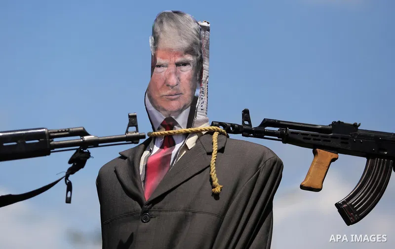 Palestinian militants from the Popular Front for the Liberation of Palestine (PFLP) aim their weapons at an effigy depicting U.S. President Donald Trump, in Gaza City May 23, 2017. Photo by Ashraf Amra