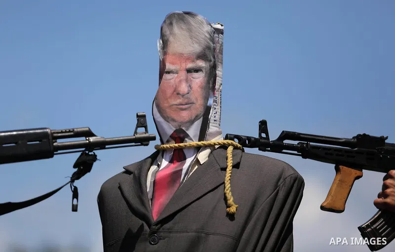 Palestinian militants from the Popular Front for the Liberation of Palestine (PFLP) aim their weapons at an effigy depicting U.S. President Donald Trump, in Gaza City May 23, 2017. Photo by Ashraf Amra