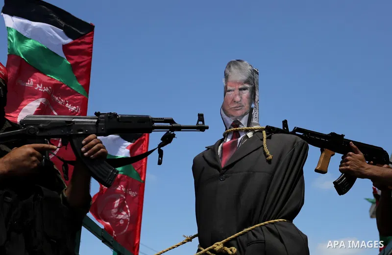 Palestinian militants from the Popular Front for the Liberation of Palestine (PFLP) aim their weapons at an effigy depicting U.S. President Donald Trump, in Gaza City May 23, 2017. Photo by Ashraf Amra