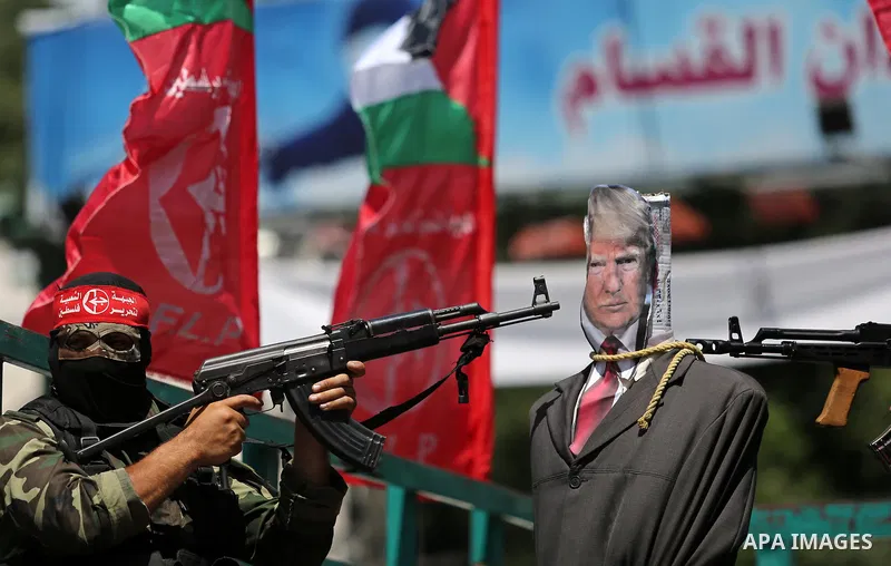 Palestinian militants from the Popular Front for the Liberation of Palestine (PFLP) aim their weapons at an effigy depicting U.S. President Donald Trump, in Gaza City May 23, 2017. Photo by Ashraf Amra