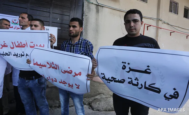 Palestinians hold banners during a protest against decision of Palestinian Authority halting shipments of baby formula and medicines to hospitals on Gaza strip, in Gaza city on May 23, 2017. Photo by Mohammed Asad