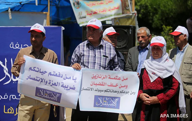Palestinian Journalists from al-Estqlal newspaper hold placards during a protest in support of Palestinian hunger-striking prisoners held in Israeli jails, as they work on printing special edition at protest tent in Gaza...