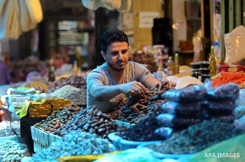A Palestinian vendor sells dates at a market ahead of the Muslim holy month of Ramadan, in Gaza city, on May 25, 2017 as the faithful prepare to start fasting. Photo by Ashraf Amra