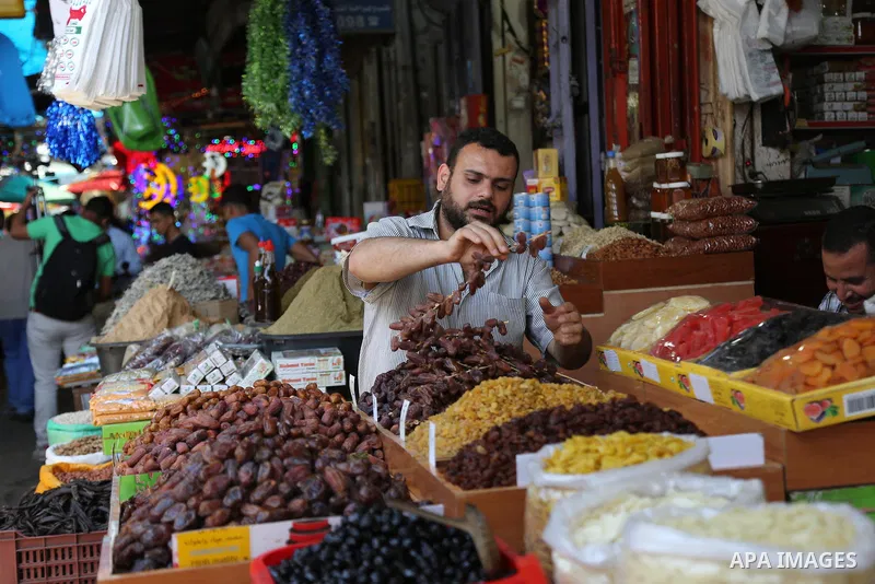 A Palestinian vendor sells dates at a market ahead of the Muslim holy month of Ramadan, in Gaza city, on May 25, 2017 as the faithful prepare to start fasting. Photo by Ashraf Amra