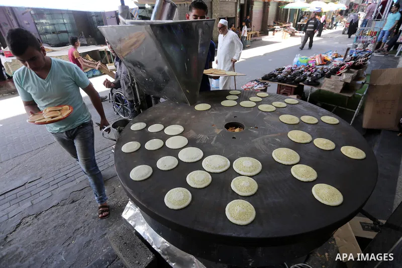 A Palestinian vendor prepares traditional pancakes known as ''Qatayef'' on the holy month of Ramadan at market in Gaza city on May 27, 2017. Ramadan is sacred to Muslims because it is during that month that tradition say...