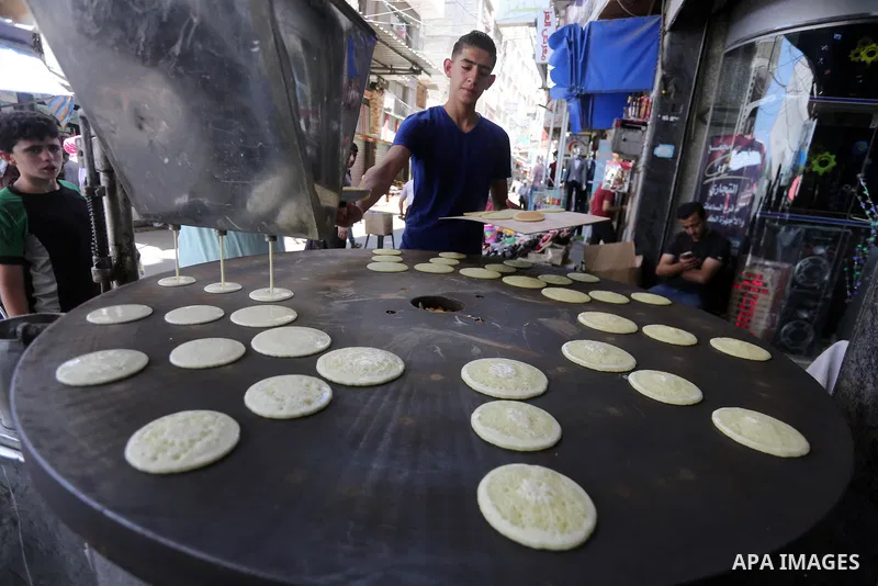 A Palestinian vendor prepares traditional pancakes known as ''Qatayef'' on the holy month of Ramadan at market in Gaza city on May 27, 2017. Ramadan is sacred to Muslims because it is during that month that tradition say...