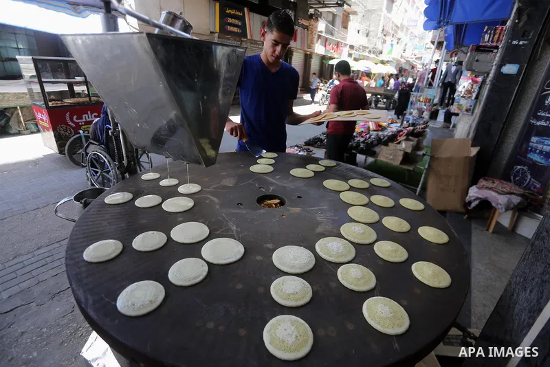 A Palestinian vendor prepares traditional pancakes known as ''Qatayef'' on the holy month of Ramadan at market in Gaza city on May 27, 2017. Ramadan is sacred to Muslims because it is during that month that tradition say...