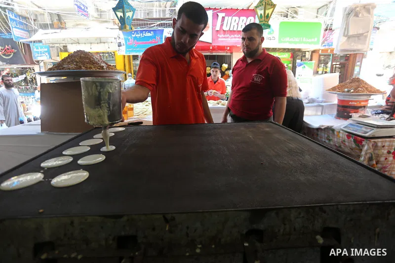 A Palestinian vendor prepares traditional pancakes known as ''Qatayef'' on the holy month of Ramadan at market in Gaza city on May 27, 2017. Ramadan is sacred to Muslims because it is during that month that tradition say...