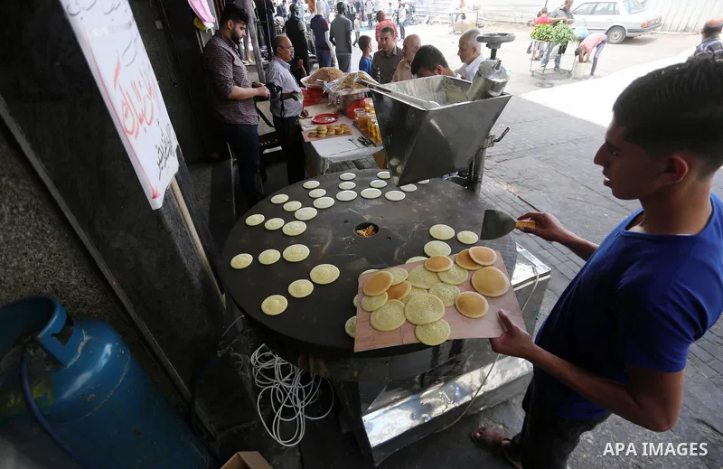 A Palestinian vendor prepares traditional pancakes known as ''Qatayef'' on the holy month of Ramadan at market in Gaza city on May 27, 2017. Ramadan is sacred to Muslims because it is during that month that tradition say...