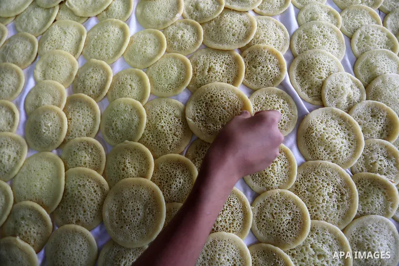 A Palestinian vendor prepares traditional pancakes known as ''Qatayef'' on the holy month of Ramadan at market in Gaza city on May 27, 2017. Ramadan is sacred to Muslims because it is during that month that tradition say...
