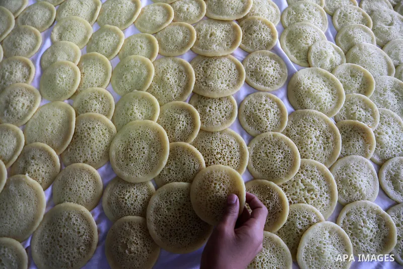 A Palestinian vendor prepares traditional pancakes known as ''Qatayef'' on the holy month of Ramadan at market in Gaza city on May 27, 2017. Ramadan is sacred to Muslims because it is during that month that tradition say...