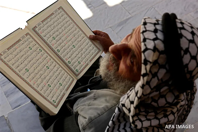 A Palestinian man reads a copy of the Koran, Islam's holiest book, on the first day of fasting in the Muslim holy month of Ramadan, at the al-Omari mosque in Gaza City, on May 27, 2017. Ramadan is sacred to Muslims becau...