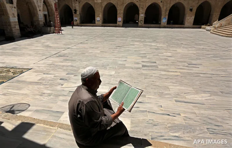 A Palestinian man reads a copy of the Koran, Islam's holiest book, on the first day of fasting in the Muslim holy month of Ramadan, at the al-Omari mosque in Gaza City, on May 27, 2017. Ramadan is sacred to Muslims becau...