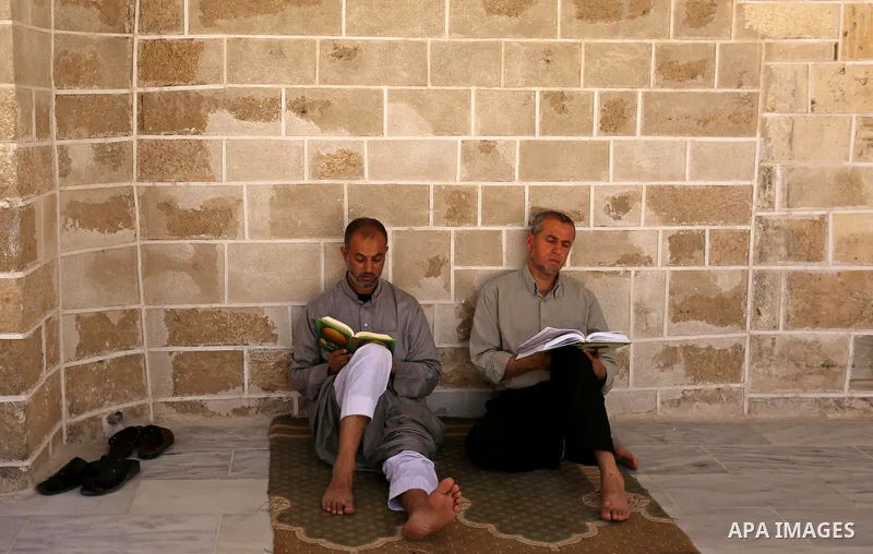 Palestinians read copies of the Koran, Islam's holiest book, on the first day of fasting in the Muslim holy month of Ramadan, at the al-Omari mosque in Gaza City, on May 27, 2017. Ramadan is sacred to Muslims because it...