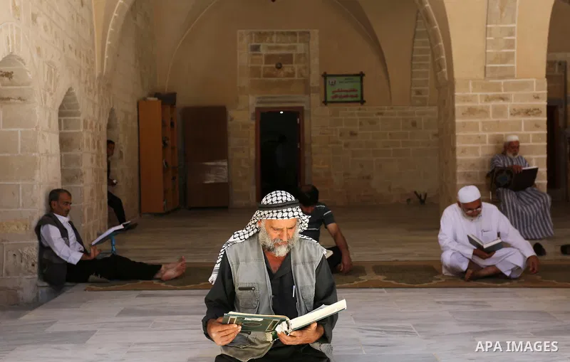 A Palestinian man reads a copy of the Koran, Islam's holiest book, on the first day of fasting in the Muslim holy month of Ramadan, at the al-Omari mosque in Gaza City, on May 27, 2017. Ramadan is sacred to Muslims becau...
