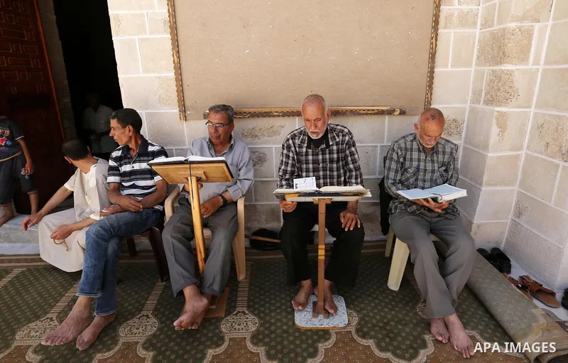 Palestinians read copies of the Koran, Islam's holiest book, on the first day of fasting in the Muslim holy month of Ramadan, at the al-Omari mosque in Gaza City, on May 27, 2017. Ramadan is sacred to Muslims because it...