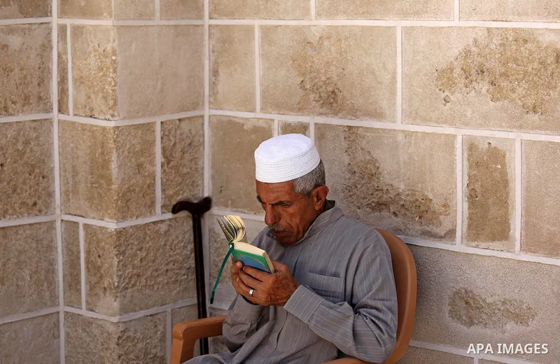 A Palestinian man reads a copy of the Koran, Islam's holiest book, on the first day of fasting in the Muslim holy month of Ramadan, at the al-Omari mosque in Gaza City, on May 27, 2017. Ramadan is sacred to Muslims becau...