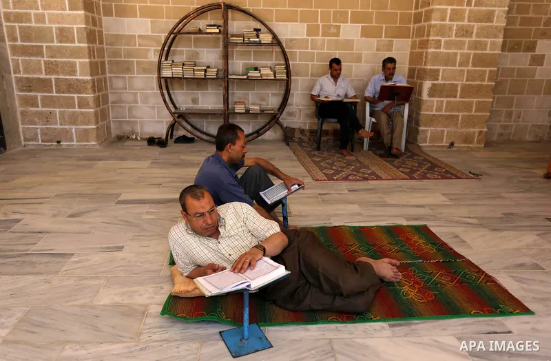 Palestinians read copies of the Koran, Islam's holiest book, on the first day of fasting in the Muslim holy month of Ramadan, at the al-Omari mosque in Gaza City, on May 27, 2017. Ramadan is sacred to Muslims because it...